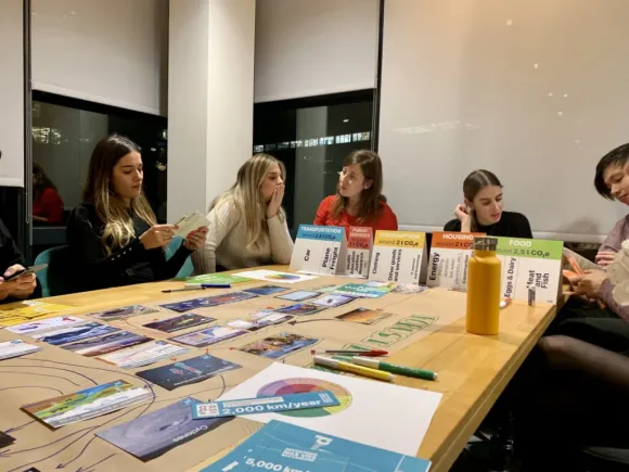 People at a table reviewing cards and charts related to sustainability and B Corp certification.